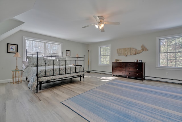 bedroom featuring baseboard heating, a baseboard radiator, wood finished floors, and baseboards