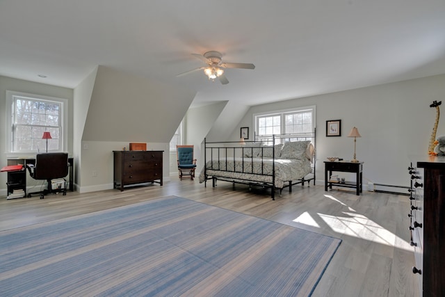 bedroom with a baseboard radiator, wood finished floors, vaulted ceiling, and baseboards