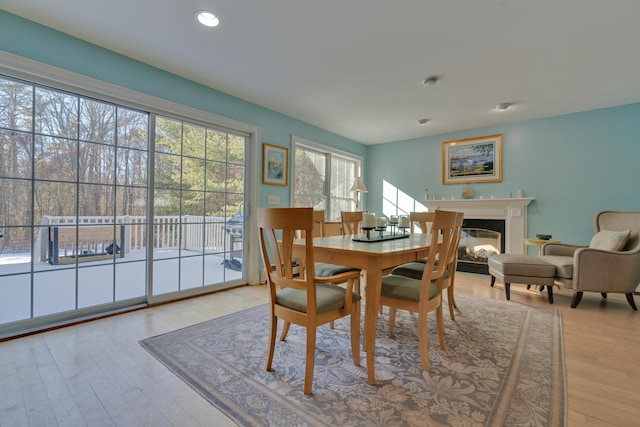 dining room with recessed lighting, wood finished floors, and a glass covered fireplace