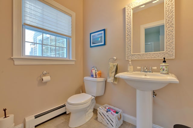 bathroom featuring baseboards, a baseboard heating unit, toilet, and tile patterned flooring