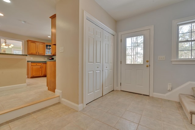 foyer featuring light tile patterned flooring, recessed lighting, and baseboards