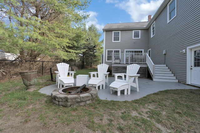 rear view of property with an outdoor fire pit, fence, stairs, a patio, and a lawn