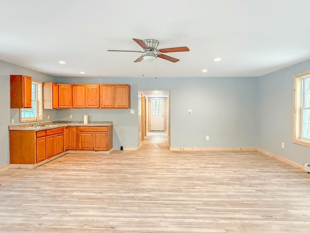 21 Coolidge Rd, Dixfield, ME 04224 - kitchen with a ceiling fan, brown cabinets, a sink, baseboards, and light wood-style flooring