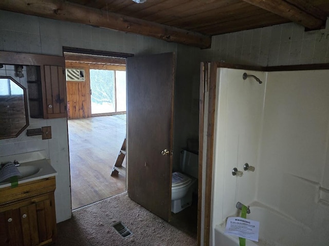 interior space featuring beam ceiling, wooden ceiling, toilet, and vanity