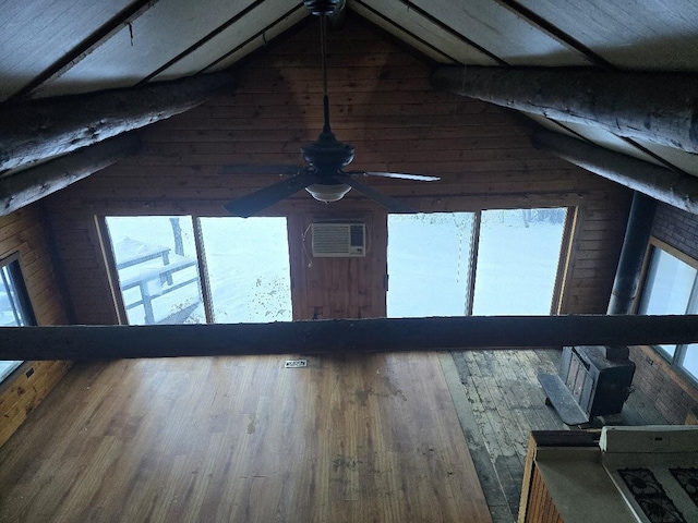 interior details with wood walls, an AC wall unit, and wood finished floors