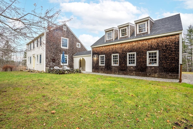 view of front of house with an outdoor structure and a front lawn