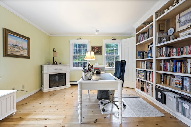 office space featuring a baseboard heating unit, ornamental molding, and light hardwood / wood-style floors