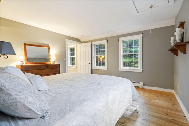 bedroom with light hardwood / wood-style flooring and baseboard heating