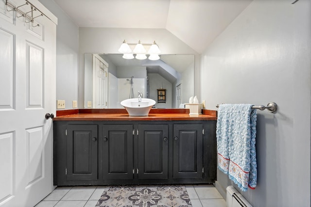 bathroom with vanity, vaulted ceiling, a baseboard heating unit, and tile patterned floors