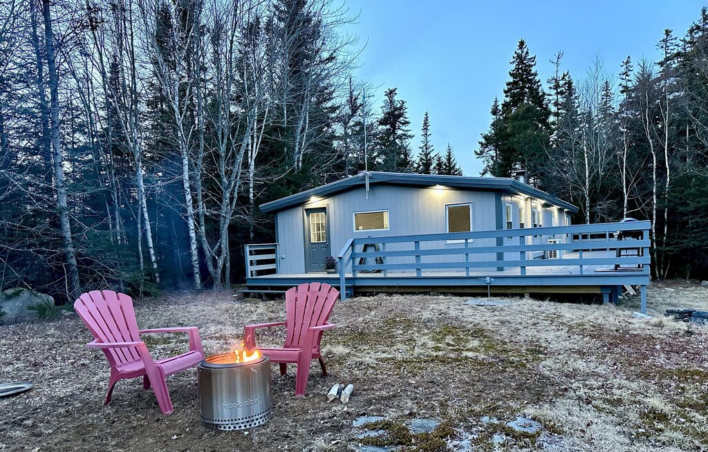 rear view of house with a wooden deck and a fire pit