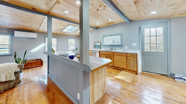 kitchen featuring stainless steel dishwasher, wooden ceiling, light hardwood / wood-style floors, and an AC wall unit