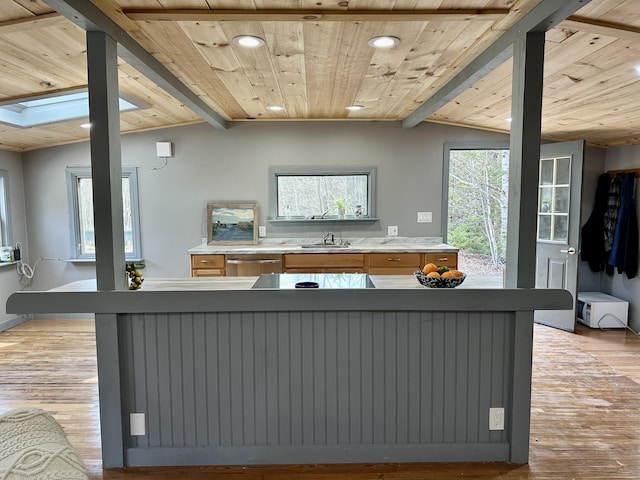 kitchen with lofted ceiling with skylight, wood ceiling, and light hardwood / wood-style floors