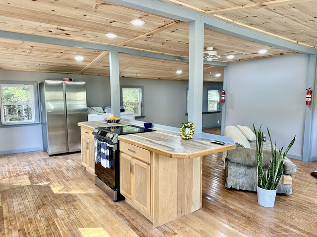 kitchen with a kitchen island, appliances with stainless steel finishes, light brown cabinets, and wood ceiling