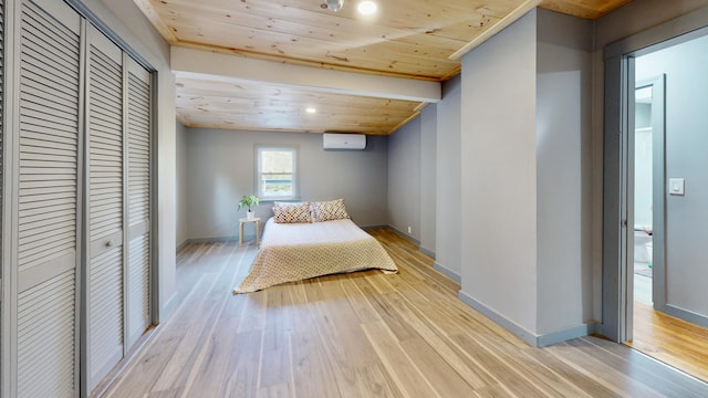 unfurnished bedroom with an AC wall unit, wooden ceiling, light wood-type flooring, and a closet