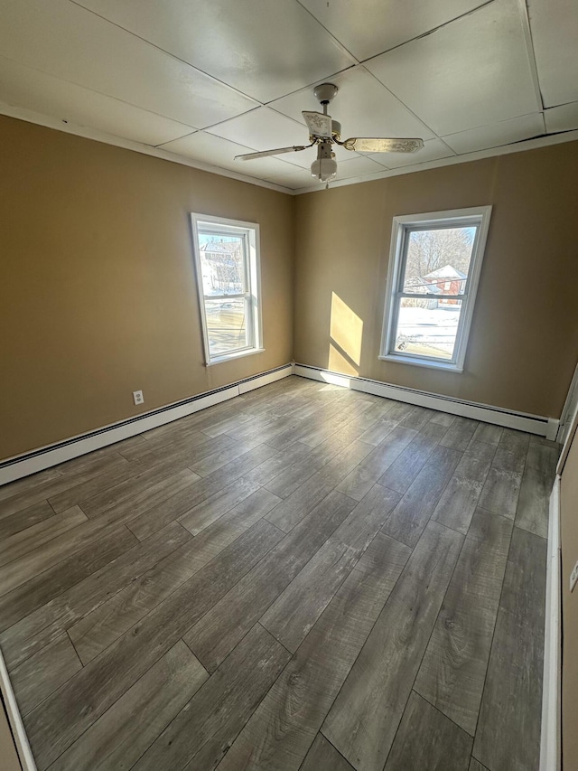 unfurnished room featuring a ceiling fan, dark wood-style flooring, crown molding, and baseboards