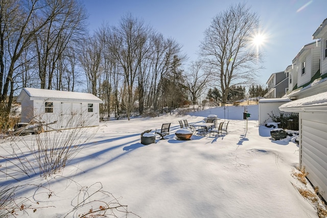 snowy yard with an outbuilding