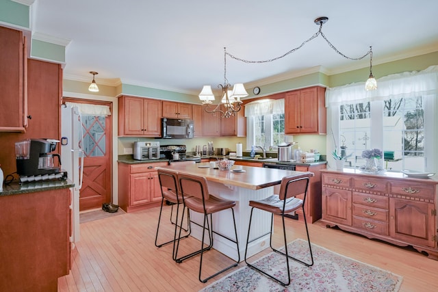 kitchen featuring stainless steel electric stove, a kitchen island, sink, light hardwood / wood-style floors, and crown molding