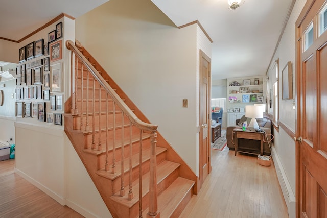 staircase featuring hardwood / wood-style flooring and ornamental molding