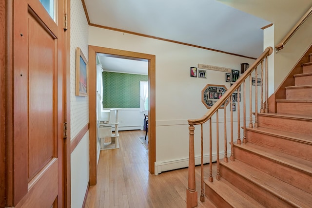 stairway featuring ornamental molding, hardwood / wood-style floors, and baseboard heating