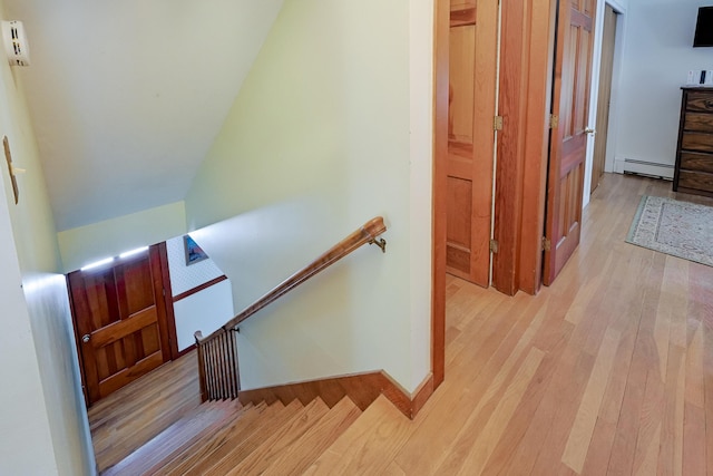 stairs featuring a baseboard radiator and wood-type flooring