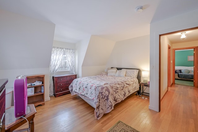 bedroom featuring vaulted ceiling and light hardwood / wood-style floors