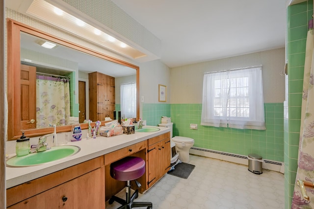 bathroom with vanity, toilet, tile walls, and a baseboard heating unit