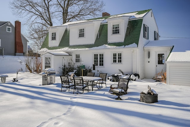 snow covered property with a shed