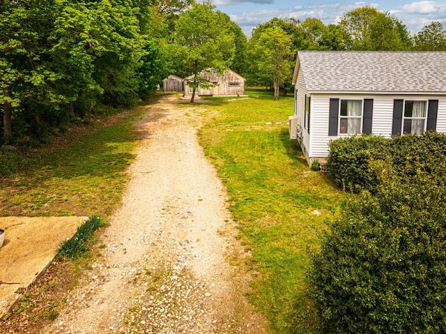 116 Rogers Rd, Kittery, ME 03904 - view of green lawn with driveway and an outbuilding