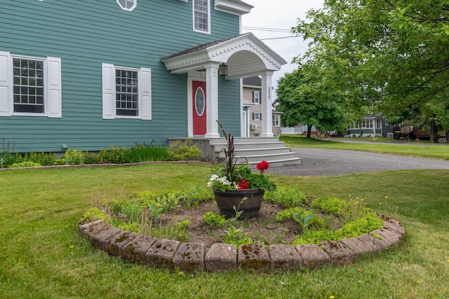 view of exterior entry with a lawn