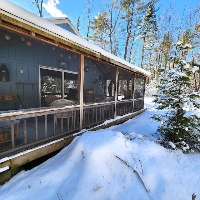 view of snow covered exterior featuring a sunroom