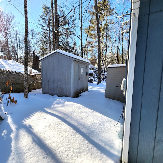 yard layered in snow featuring a storage unit