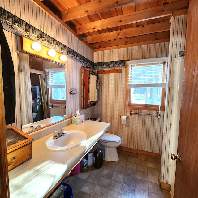 bathroom with wood ceiling, beam ceiling, plenty of natural light, and toilet