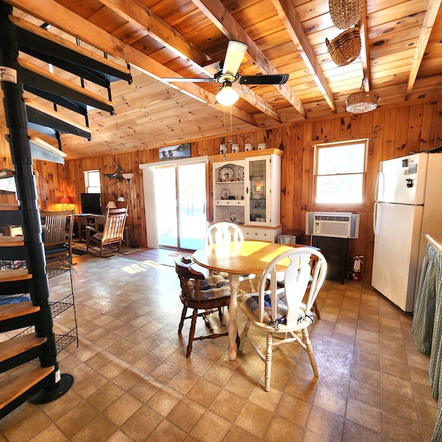 dining area with beamed ceiling, ceiling fan, wood ceiling, and wooden walls