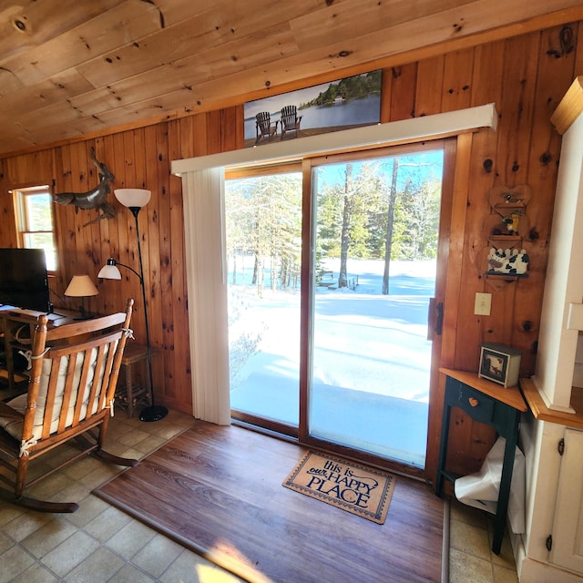 doorway featuring wood ceiling, lofted ceiling, and wooden walls