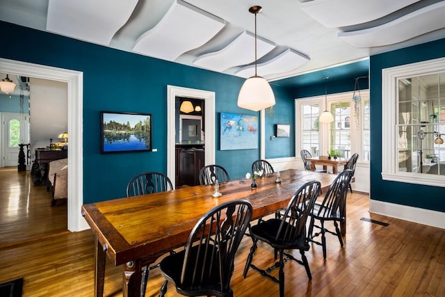 dining space with plenty of natural light and hardwood / wood-style floors