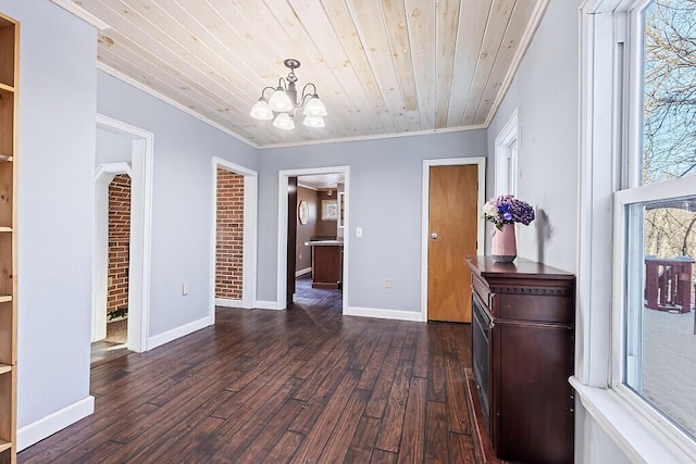 interior space featuring dark hardwood / wood-style flooring, ornamental molding, wooden ceiling, and an inviting chandelier