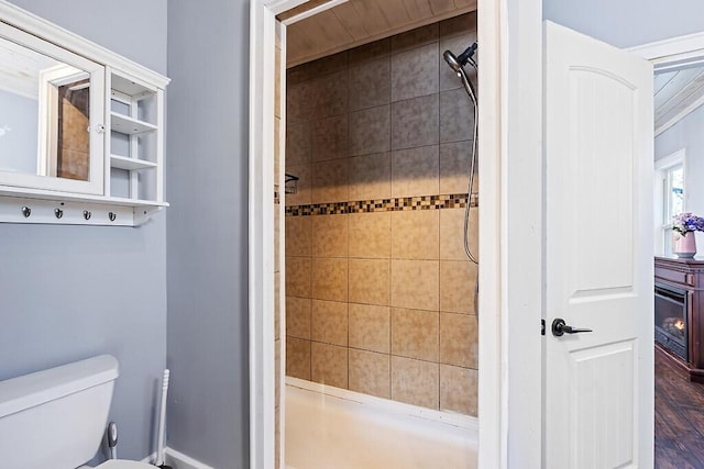 bathroom with tiled shower and toilet