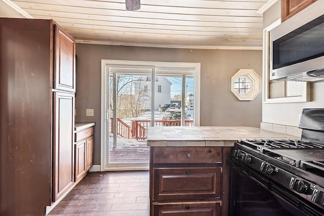 kitchen featuring dark hardwood / wood-style flooring, wood ceiling, ornamental molding, and gas stove