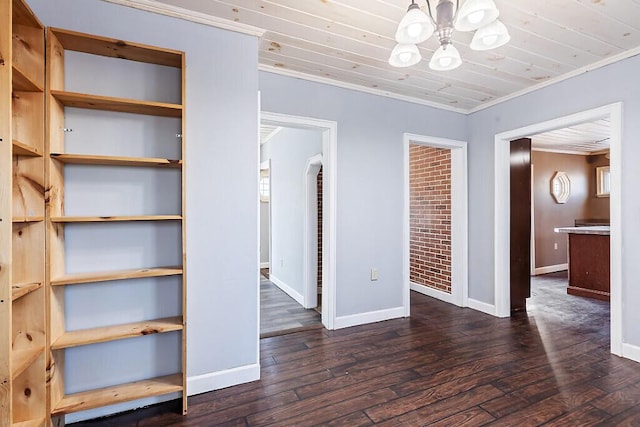 unfurnished bedroom featuring wood ceiling, dark wood-type flooring, an inviting chandelier, ornamental molding, and multiple closets