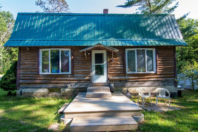 log cabin featuring a front lawn and a deck