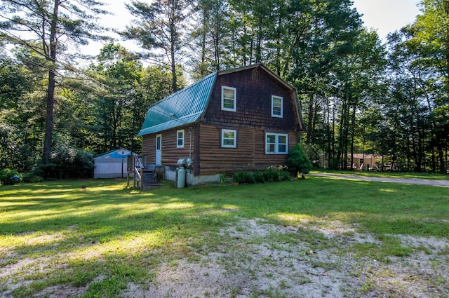 view of side of property featuring a yard and a shed