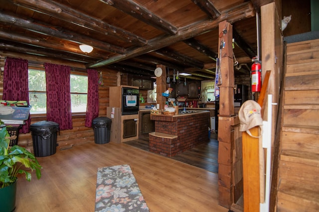 interior space with hardwood / wood-style flooring, beam ceiling, rustic walls, and wooden ceiling