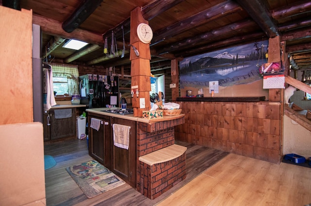 bar with stainless steel gas cooktop, wood ceiling, dark brown cabinets, beam ceiling, and light hardwood / wood-style floors