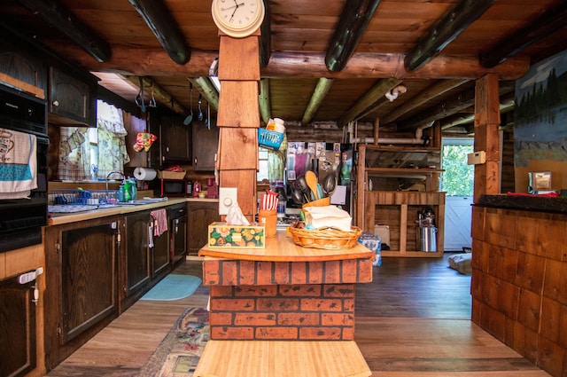 kitchen with dark brown cabinets, wooden ceiling, dark hardwood / wood-style floors, black oven, and beamed ceiling