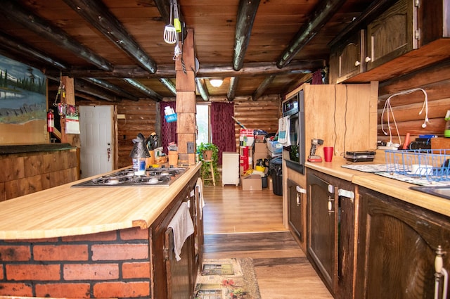 kitchen with beamed ceiling, wooden counters, wooden ceiling, appliances with stainless steel finishes, and hardwood / wood-style flooring