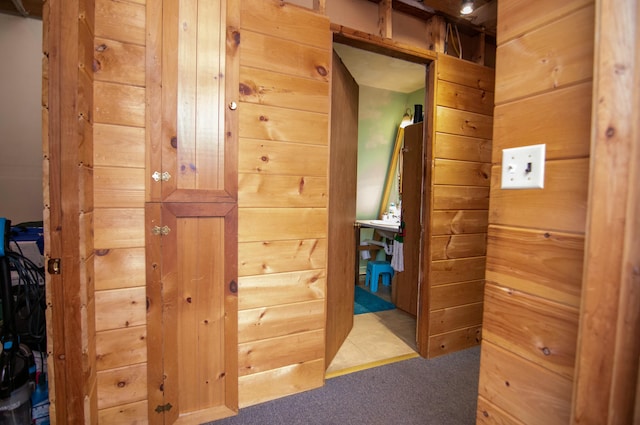 hallway with carpet floors and wood walls