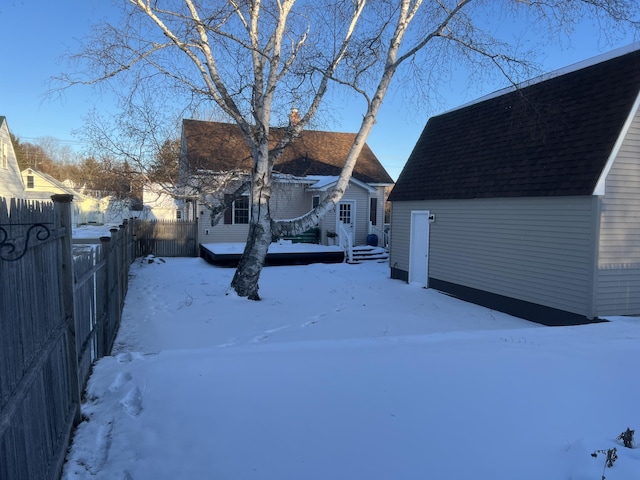 snowy yard featuring an outbuilding