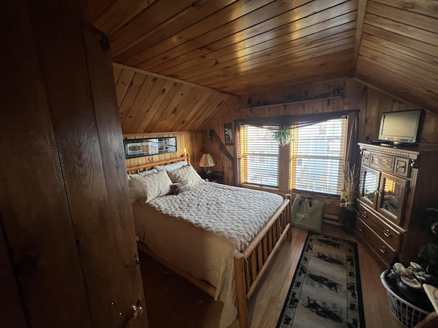 bedroom featuring hardwood / wood-style flooring, wooden walls, and vaulted ceiling