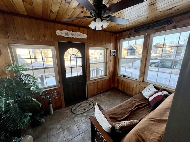 sunroom / solarium featuring ceiling fan, a wealth of natural light, and wooden ceiling