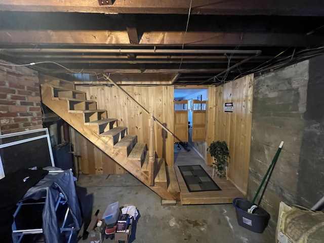 basement featuring wood walls